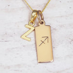Gold 'Z' initial necklace with Sagittarius Zodiac pendant on a light background.
