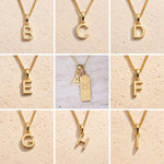 Collage of fine gold chain necklaces with uppercase gold letter B, C, D, E, F, G, H, I, A pendants on a beige background as personalised gold initial pendant options for Taurus Zodiac Necklace.