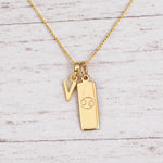 Gold Initial and Cancer Zodiac Necklace with letter V pendant on light wood