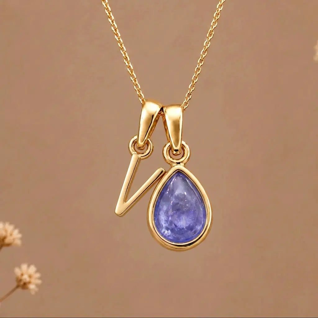 Gold Initial v and December Birthstone natural Tanzanite Necklace on a warm background