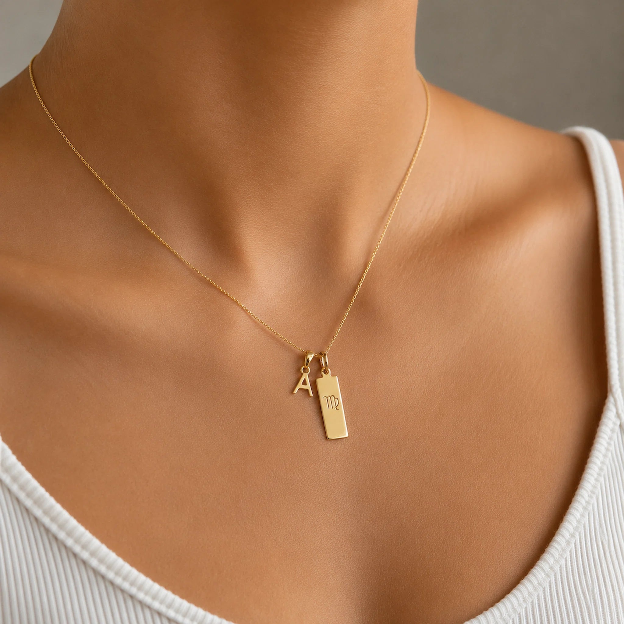woman wearing a Gold double pendant necklace with a letter pendant and a virgo zodiac glyph pendant