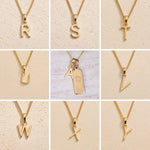 Gold necklaces with letter pendants on a beige background showing the gold initial options r, s, t, u, v, w, x, y, a for the personalised virgo zodiac necklace