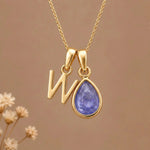 Gold Initial W and December Birthstone natural Tanzanite Necklace on a warm background
