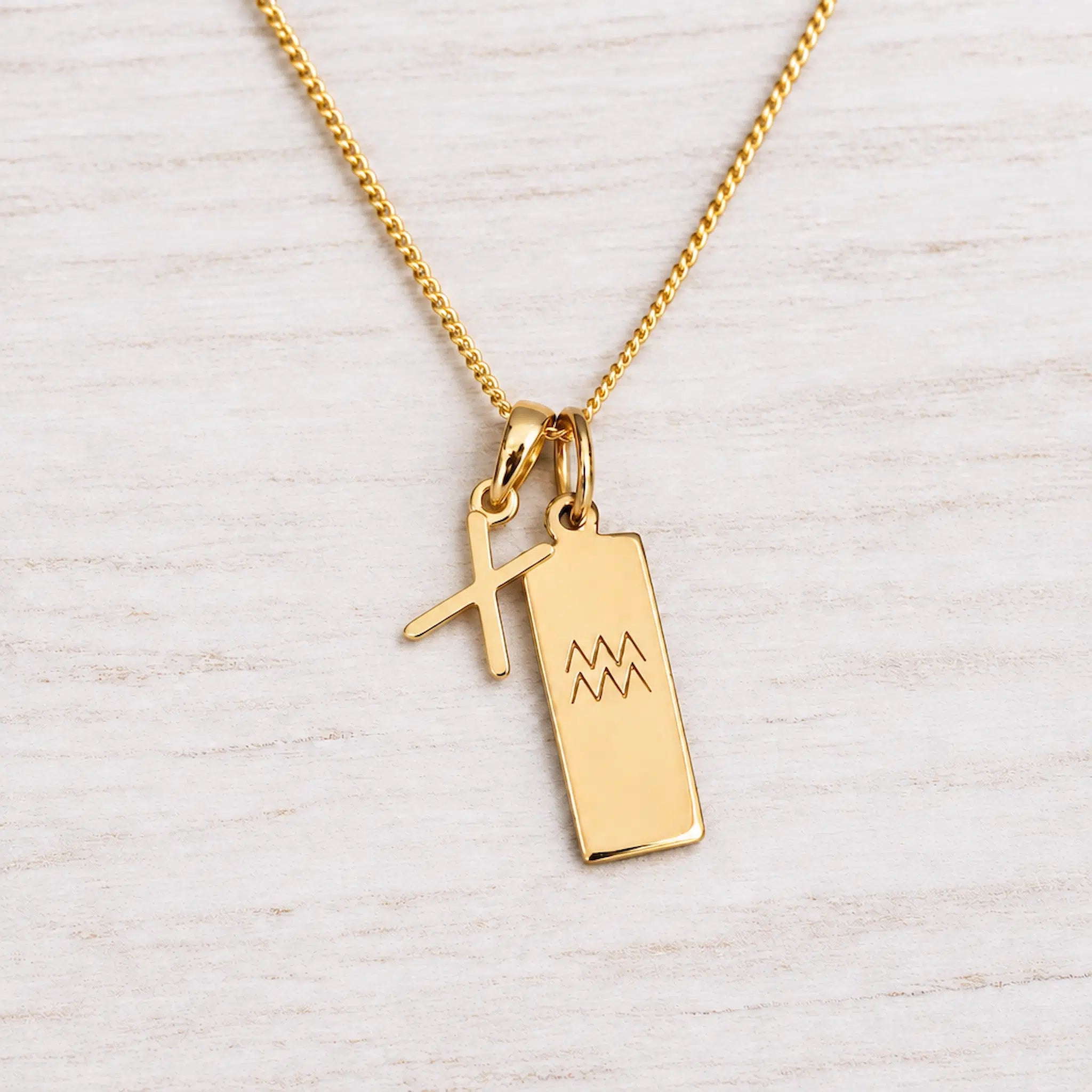 Gold Initial and Aquarius Zodiac Necklace with letter X pendant on light wood