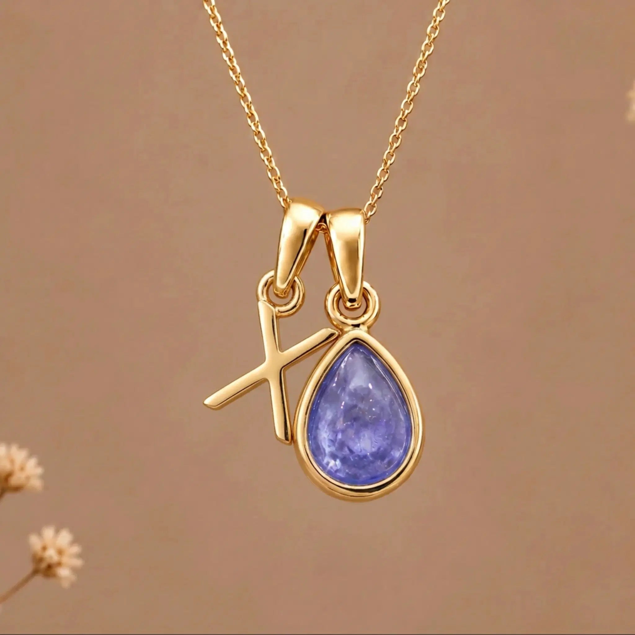 Gold Initial X and December Birthstone natural Tanzanite Necklace on a warm background