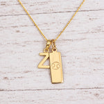 Gold Initial and Cancer Zodiac Necklace with letter Z pendant on light wood