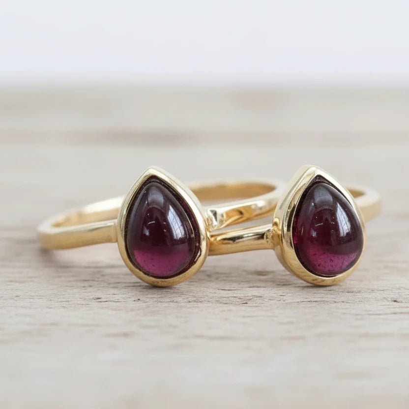 Two gold January birthstone garnet rings with teardrop garnet gemstones, Indie and Harper jewellery