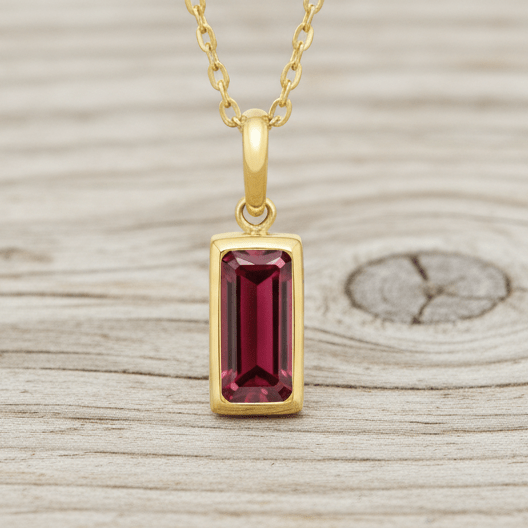 Gold necklace chain with a rectangle garnet coloured gemstone 
