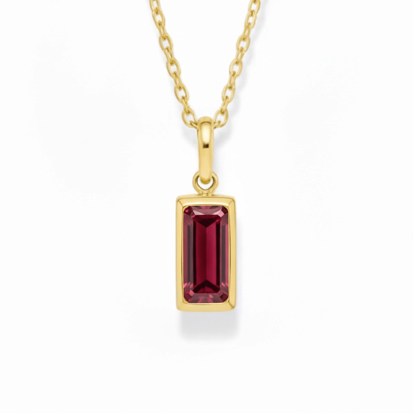gold january birthstone necklace with red cubic zirconia on a white background.