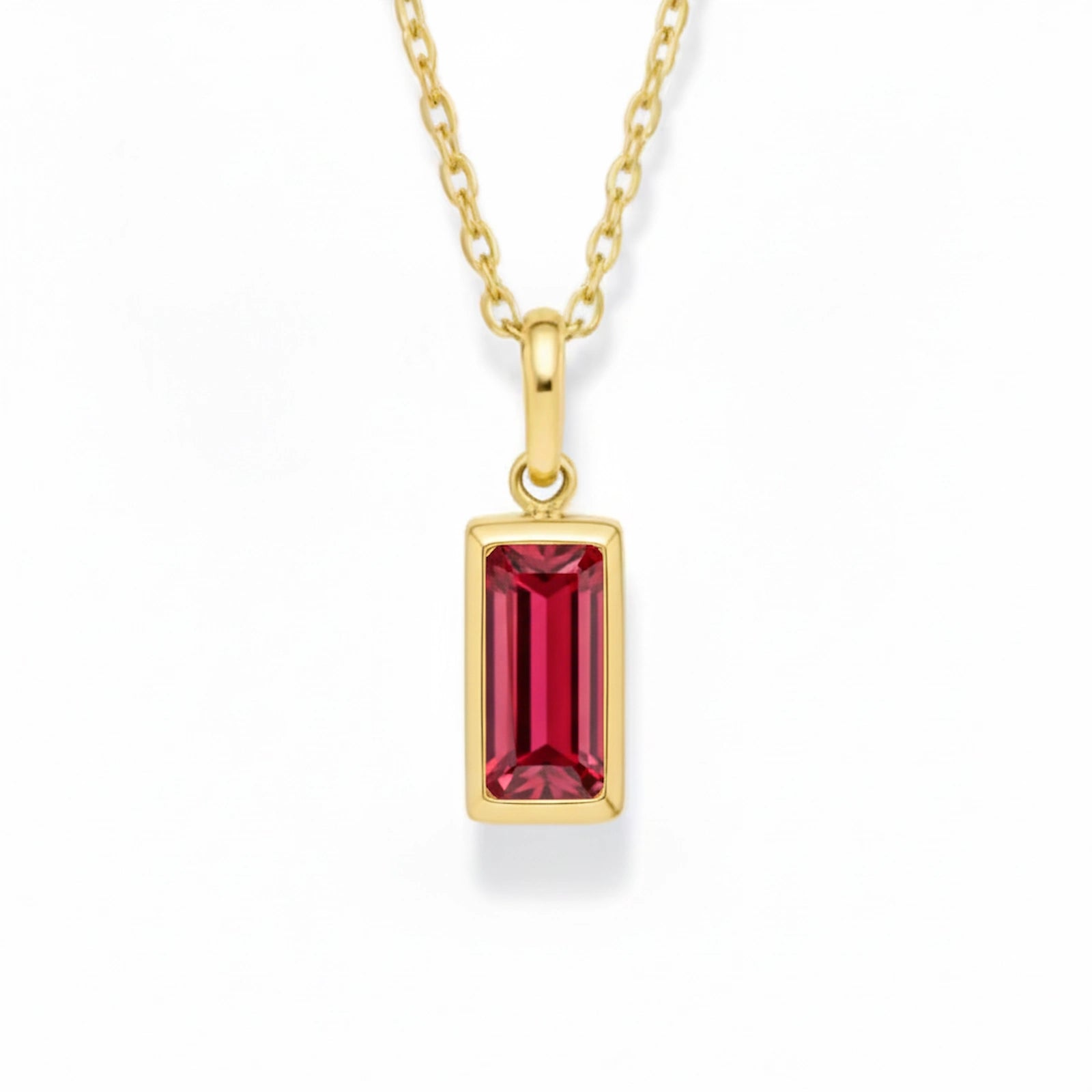 gold july birthstone necklace with red cubic zirconia on a white background.