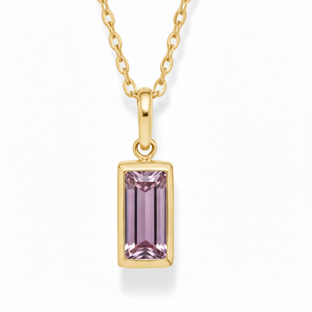 Gold necklace with a pink gemstone pendant on a white background