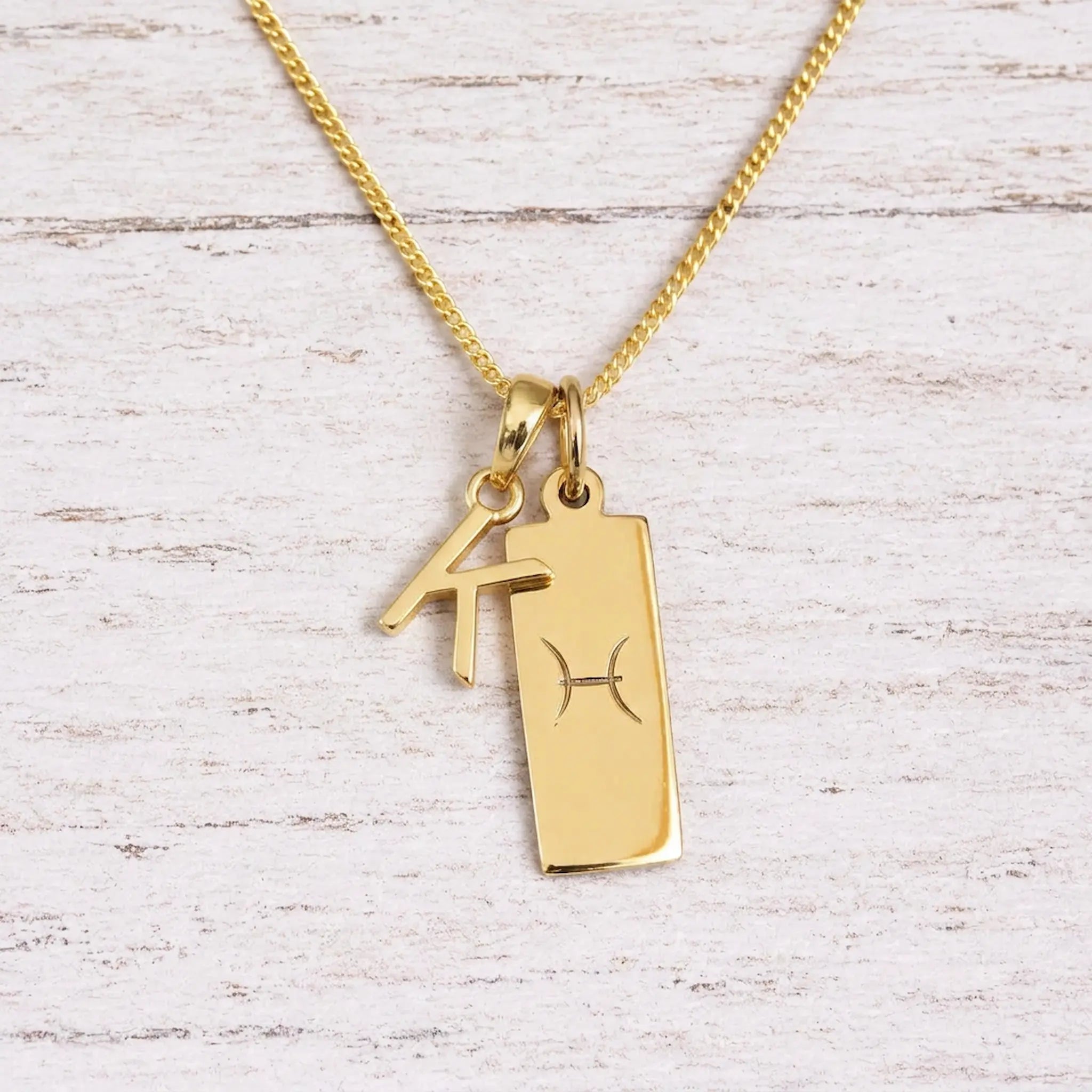 gold initial k pendant and pisces zodiac star sign pendant on a fine gold chain