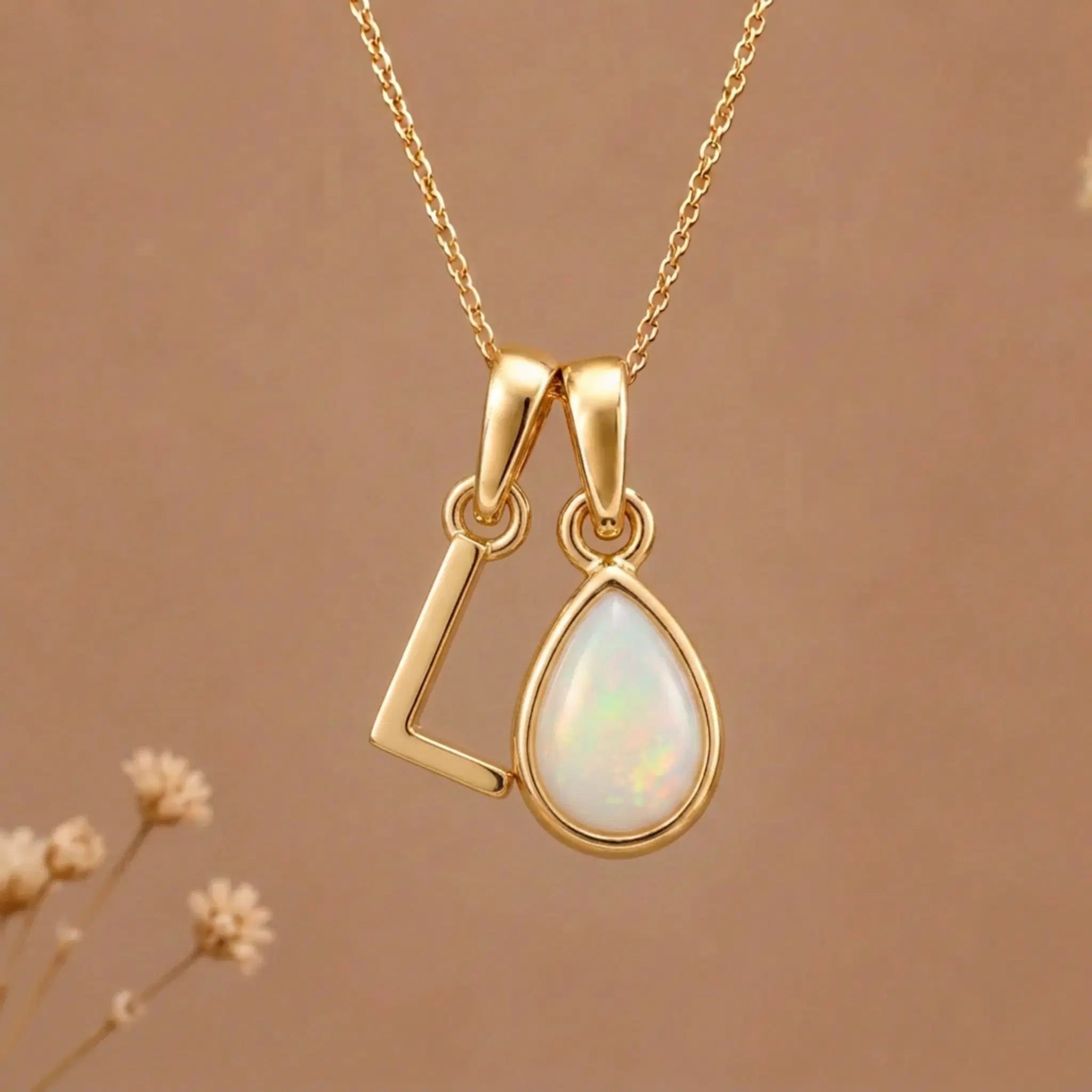 Gold Initial L Pendant and October birthstone Natural Opal Necklace against a warm background