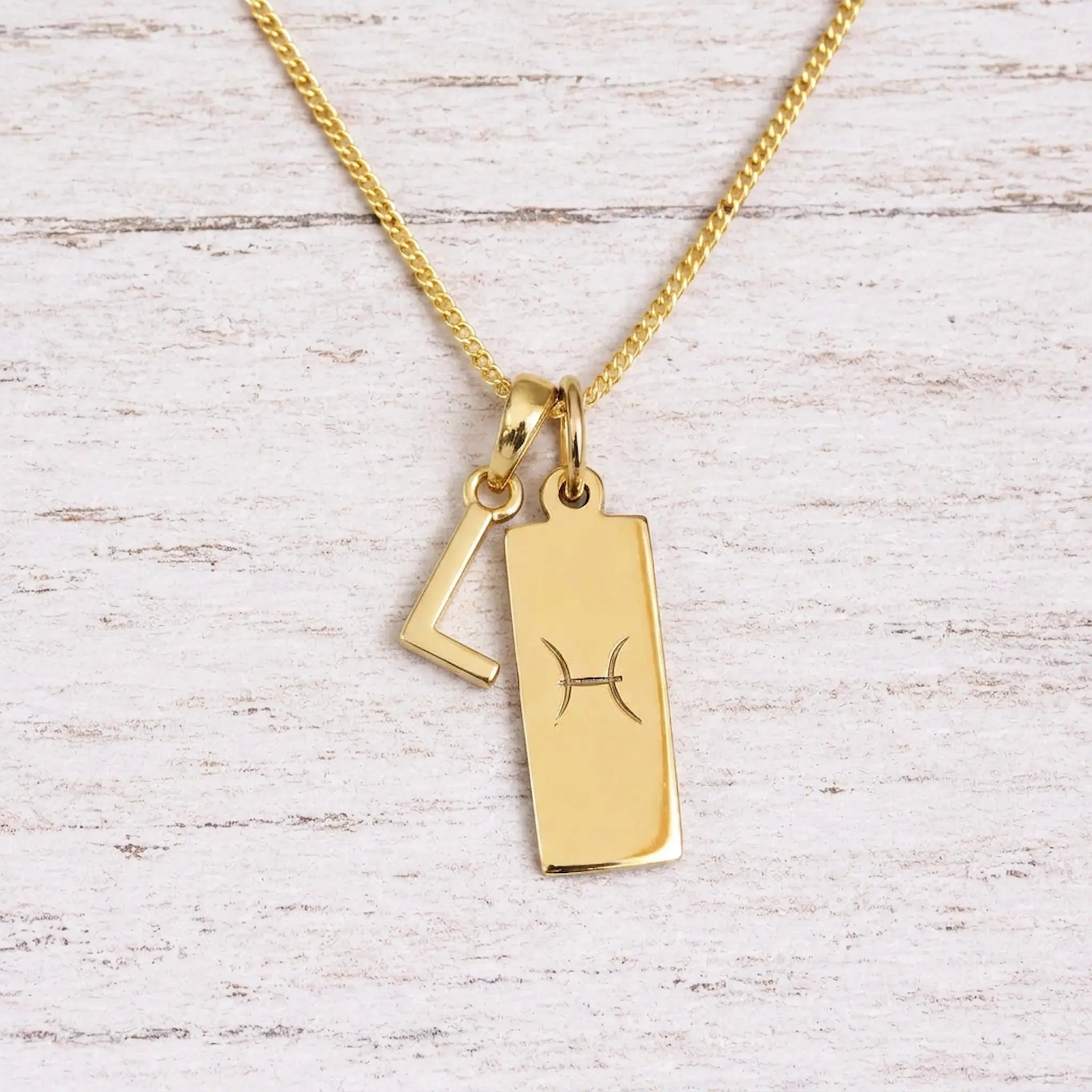 gold initial l pendant and pisces zodiac star sign pendant on a fine gold chain