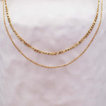 Gold chains necklace on a gray background