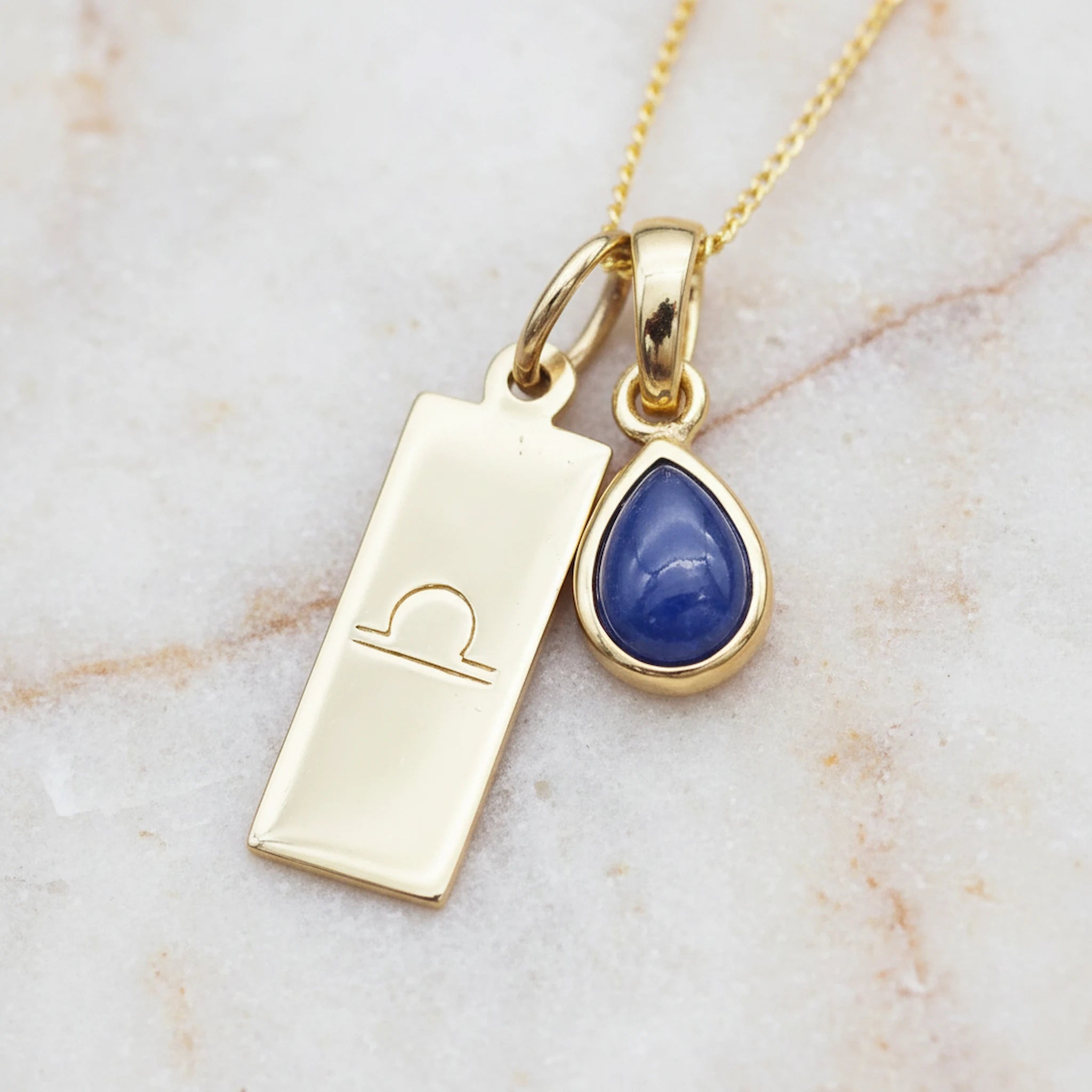 Gold Libra Zodiac necklace with a September birthstone natural sapphire gemstone pendant