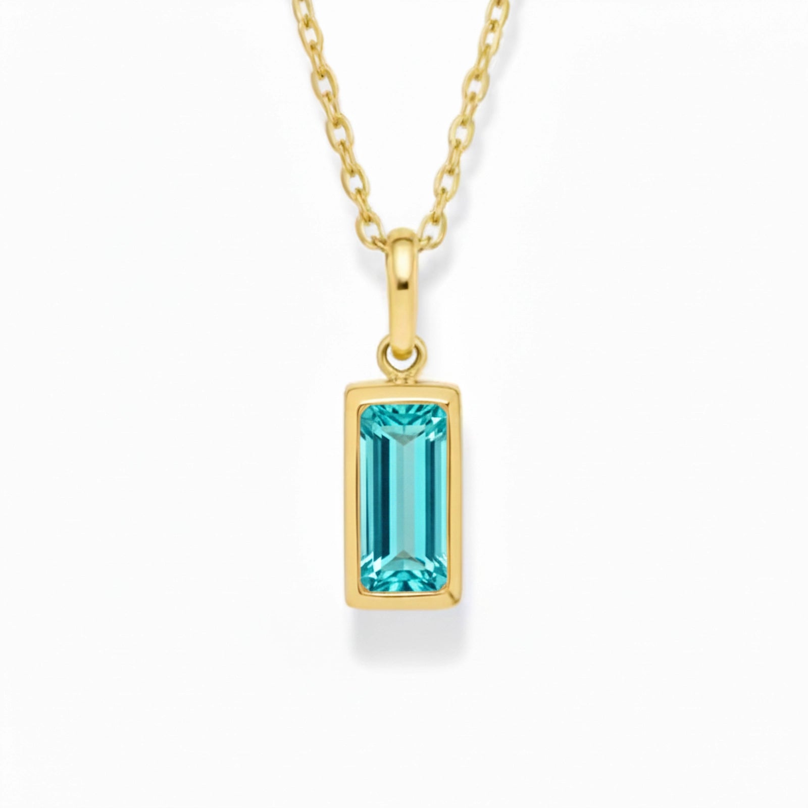 gold march birthstone necklace with blue cubic zirconia on a white background.