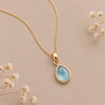 gold march birthstone necklace with teardrop cabochon bezel set natural aquamarine pendant