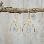 Gold earrings with teardrop-shaped moonstones gemstones on a white background