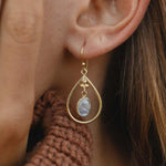 gold moonstone teardop earrings being worn