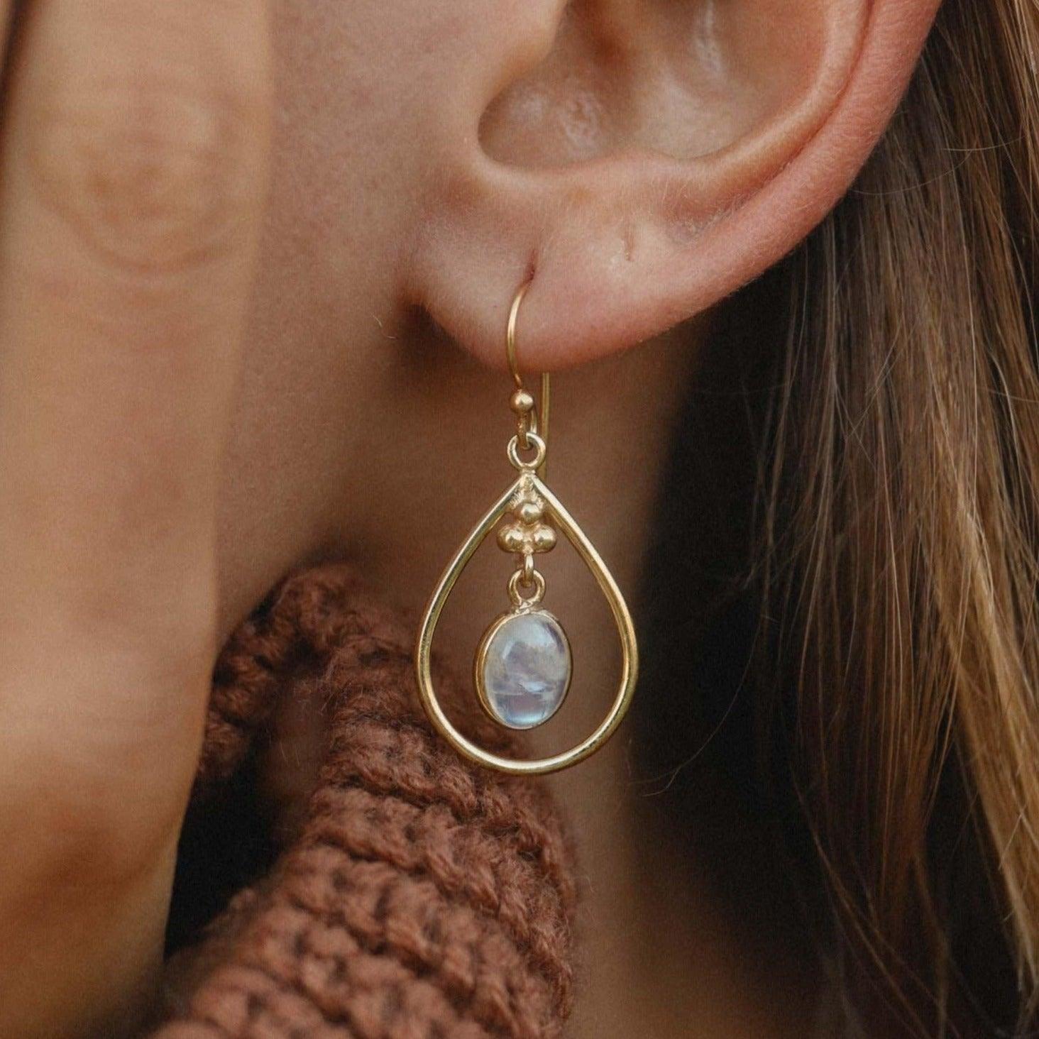 gold moonstone teardop earrings being worn