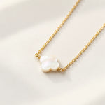 Close detail of gold mother of pearl clover pendant and chain