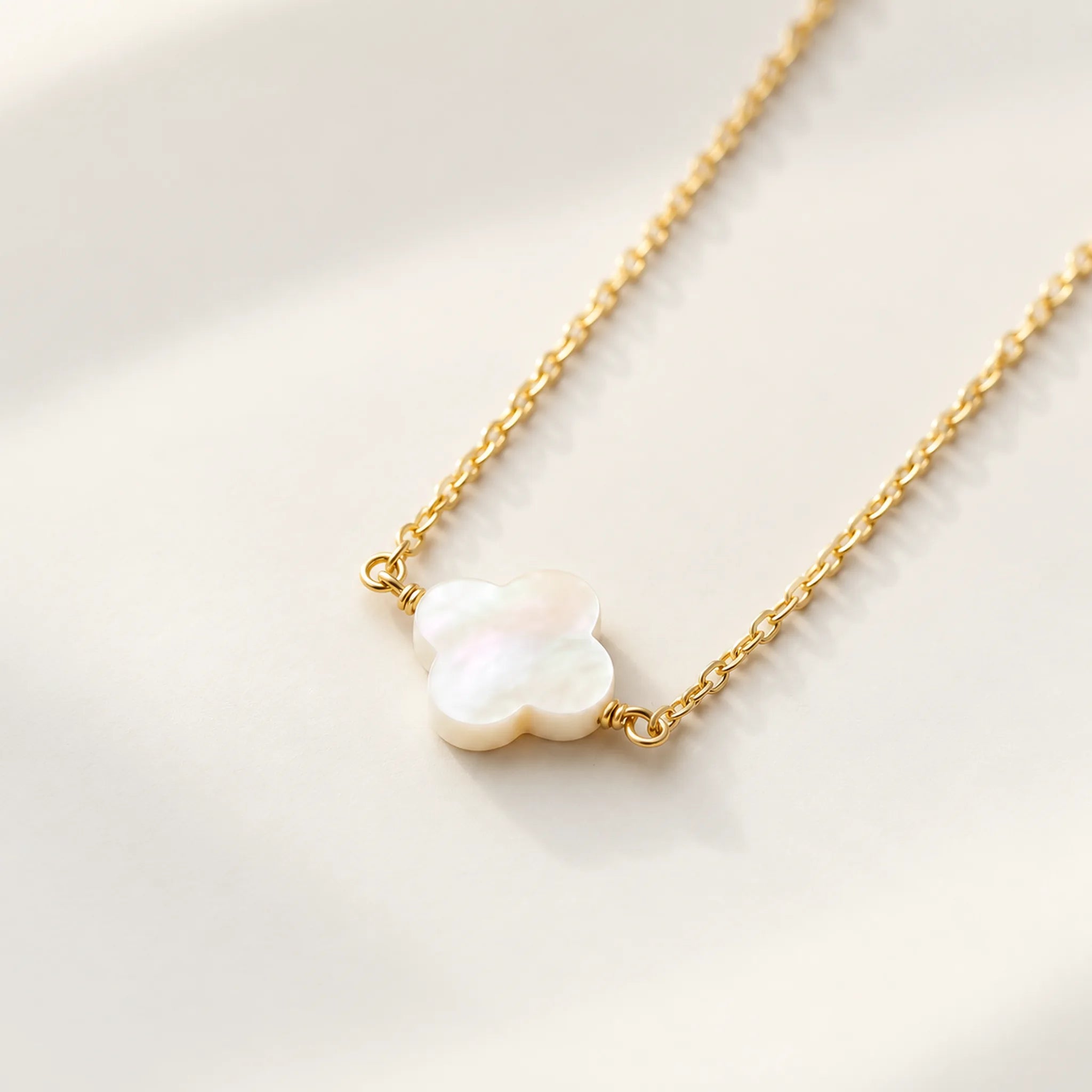 Close detail of gold mother of pearl clover pendant and chain