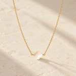 Gold mother of pearl clover necklace with softly blurred baby's breath
