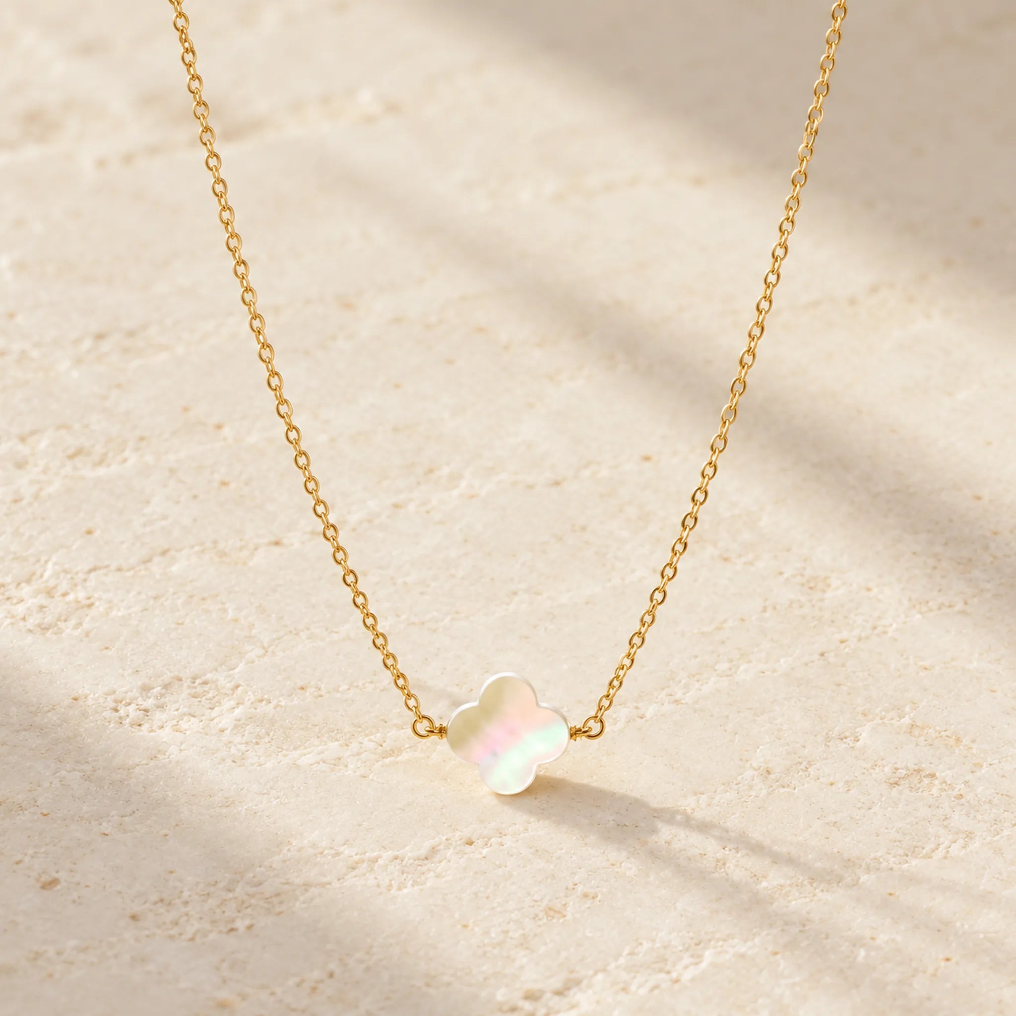 Gold mother of pearl clover necklace with softly blurred baby's breath