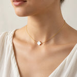 Gold mother of pearl clover necklace worn at the collarbone