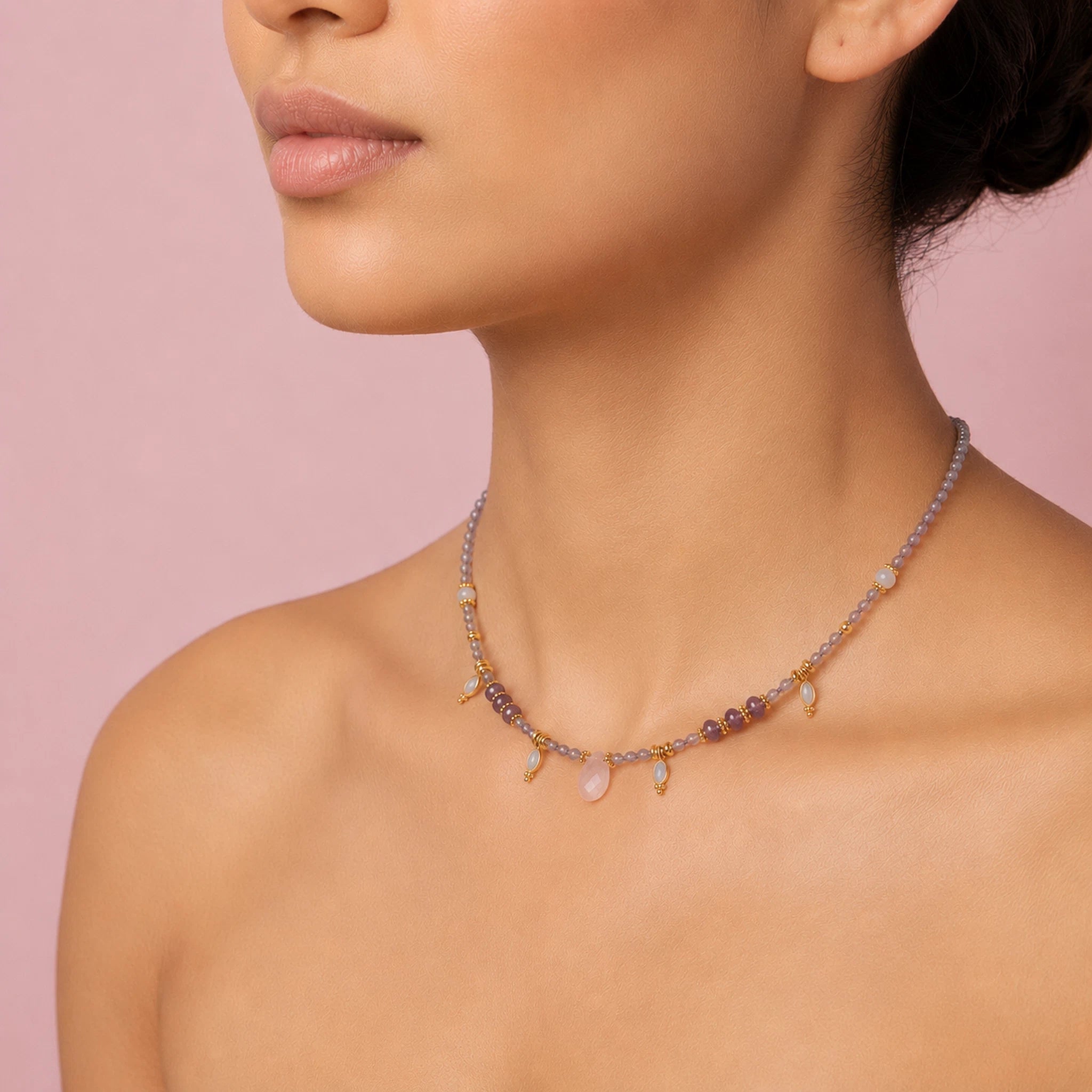 Necklace with multicolored beads on a model against a pink background