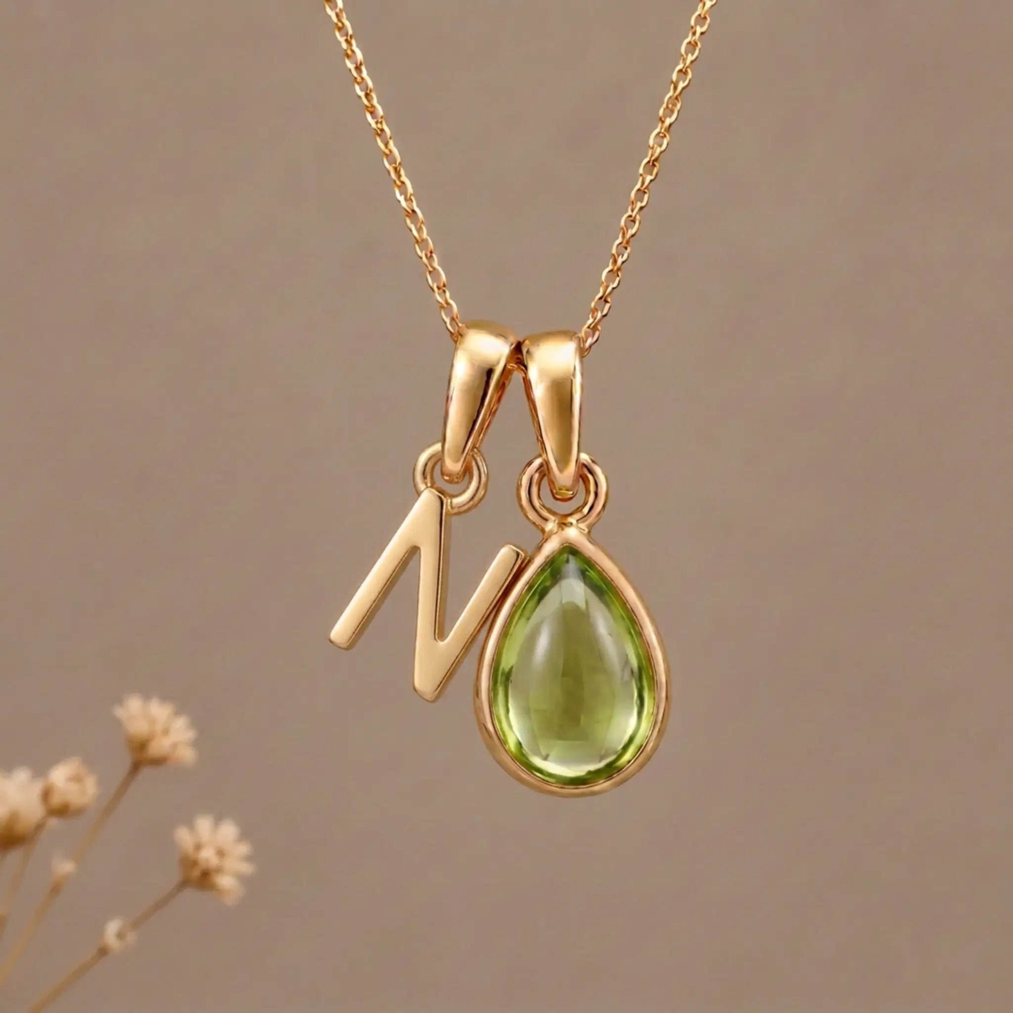 Gold Initial N Pendant and August birthstone Natural Peridot Necklace against a warm background