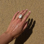 Gold cowrie shell ring being worn