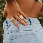 Hand wearing the gold cowrie shell ring