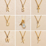 Gold necklaces with letters R to Y on a beige background showing the personalised gold letters available for the November Birthstone Blue Topaz Necklace.