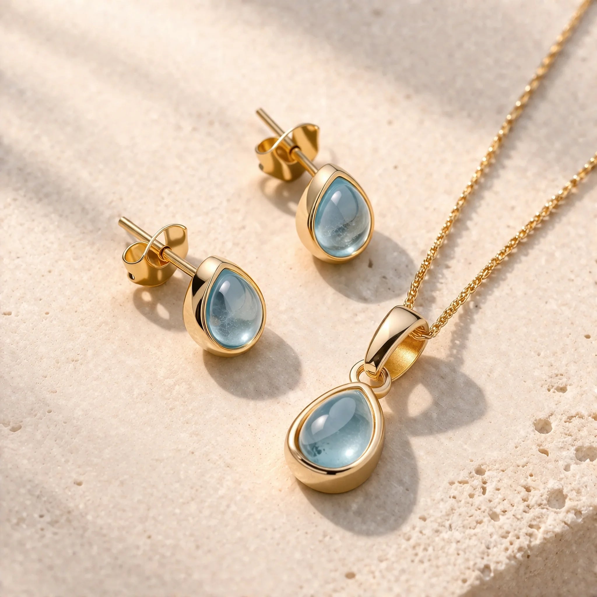 Gold November Birthstone Jewellery Set including pear-shaped natural blue topaz stud earrings and pendant necklace