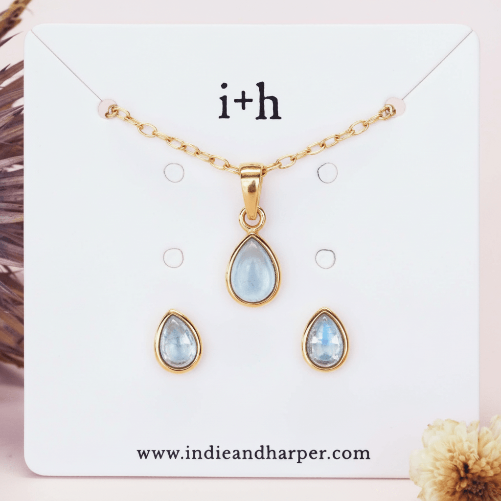Jewelry set with teardrop-shaped pendants on a display card with 'i+h' branding.
