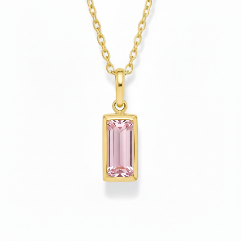 Gold necklace with a pink gemstone pendant on a white background