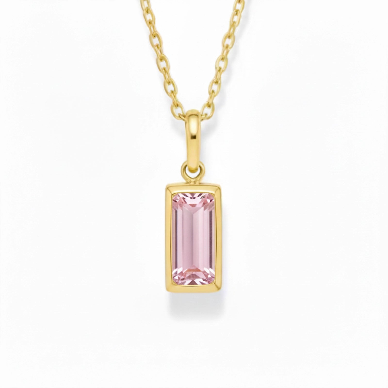 gold october birthstone necklace with pink cubic zirconia on a white background.