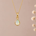 gold october birthstone necklace with a teardrop bezel-set cabochon natural opal stone pendant hanging