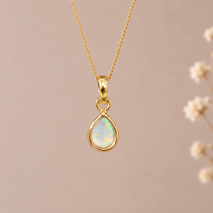 gold october birthstone necklace with a teardrop bezel-set cabochon natural opal stone pendant hanging