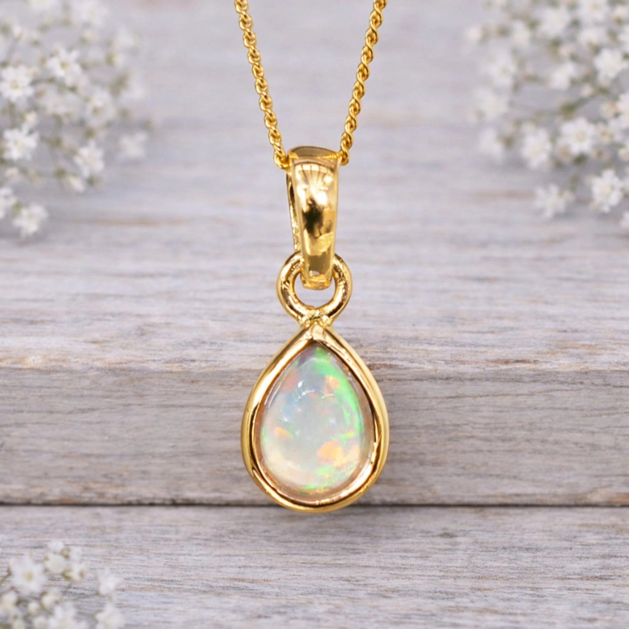 Gold October birthstone opal necklace with a bezel-set pear-shaped opal
