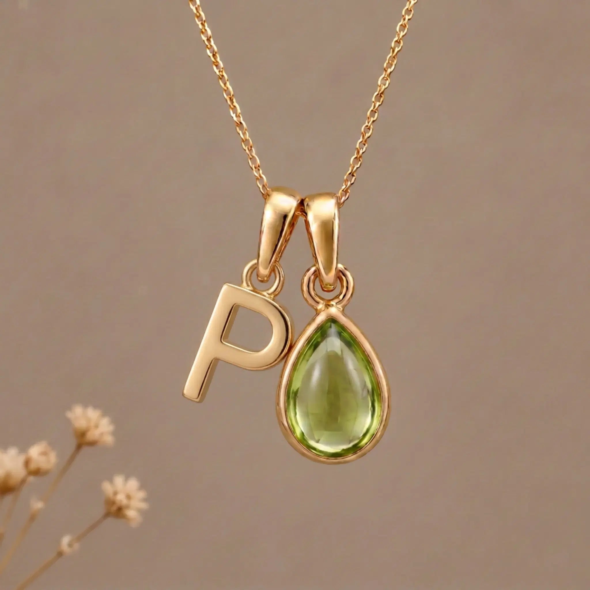 Gold Initial P Pendant and August birthstone Natural Peridot Necklace against a warm background