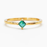 Gold-plated ring with a princess-cut emerald-green cubic zirconia on a white background
