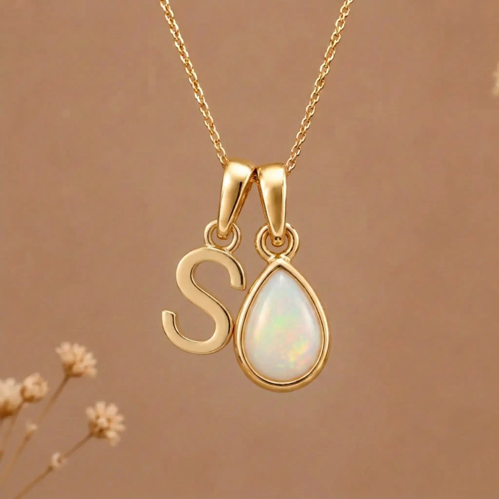 Gold Initial A Pendant and October birthstone Natural Opal Necklace against a warm background