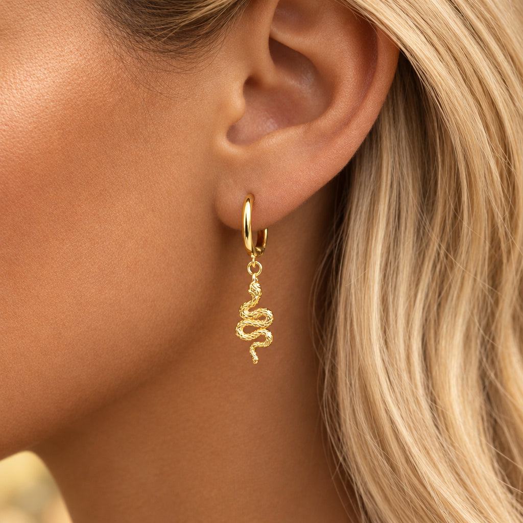 Gold serpent hoop earring worn by a woman with blonde hair