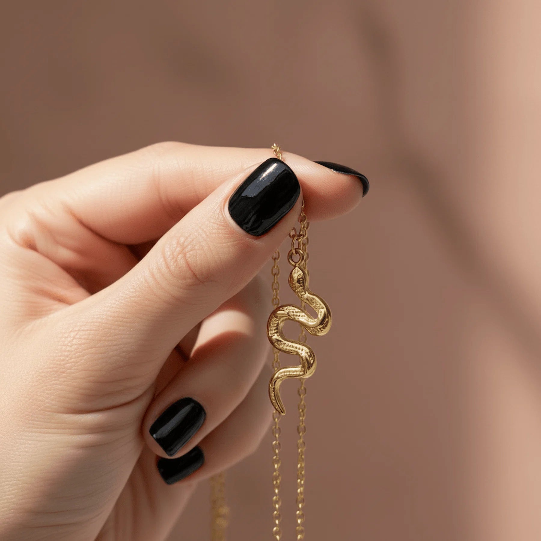 Gold serpent snake pendant necklace held
