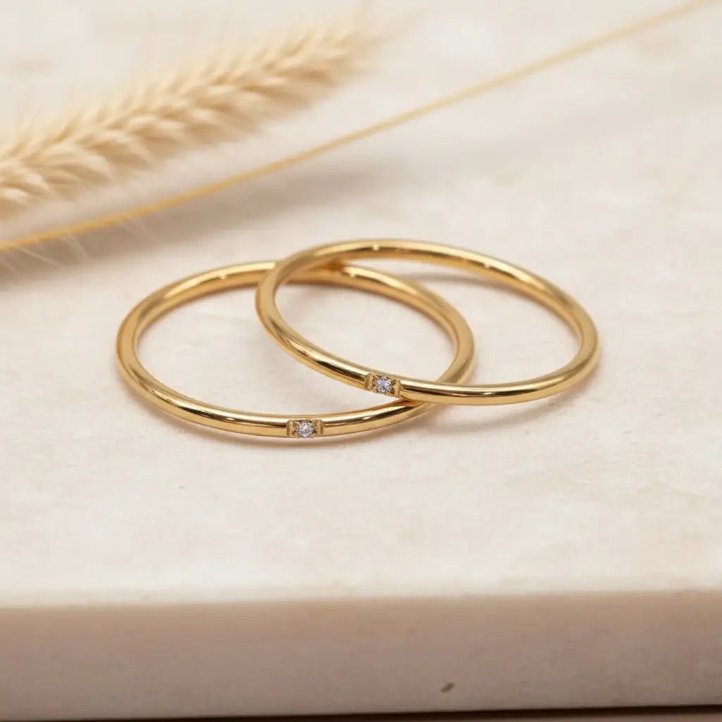 gold stacker rings on a light stone surface