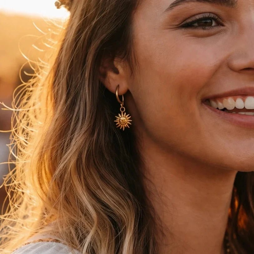 Woman wearing gold earrings and necklace with a blurred background