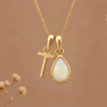 Gold Initial T Pendant and October birthstone Natural Opal Necklace against a warm background